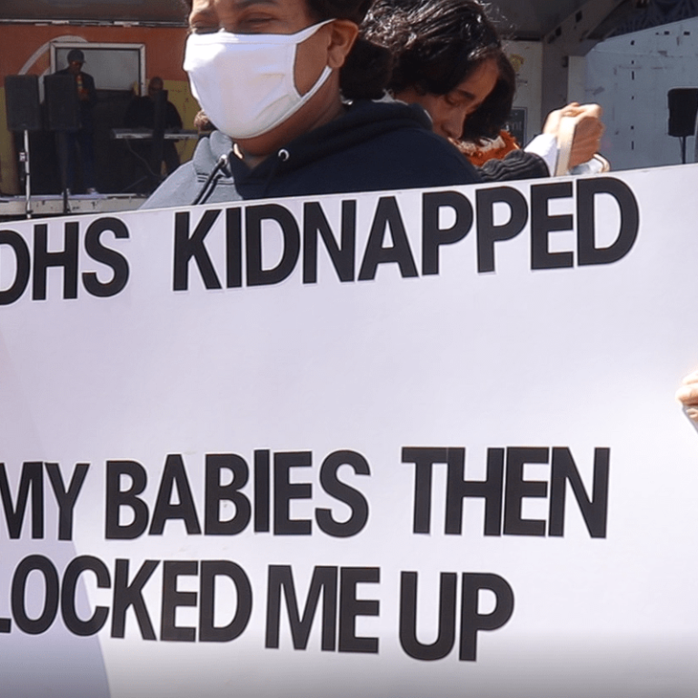 Protesters carry a sign at a May 2022 protest at LOVE Park after City Council released a scathing reports on the Department of Human Services’ lapses in caring for children. (Josh Childs)