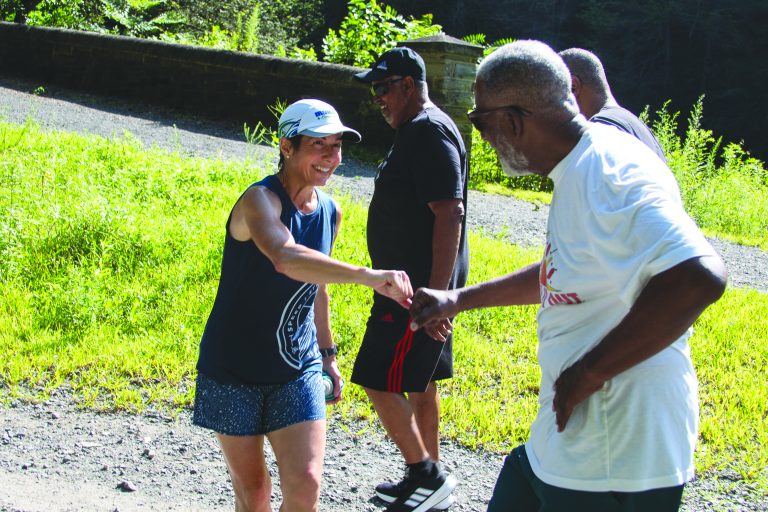 Joe Jamison greets Kathryn Rapp during a walk with Bruce Ross (in black) and Al Walker. Photo by Brian Nelson