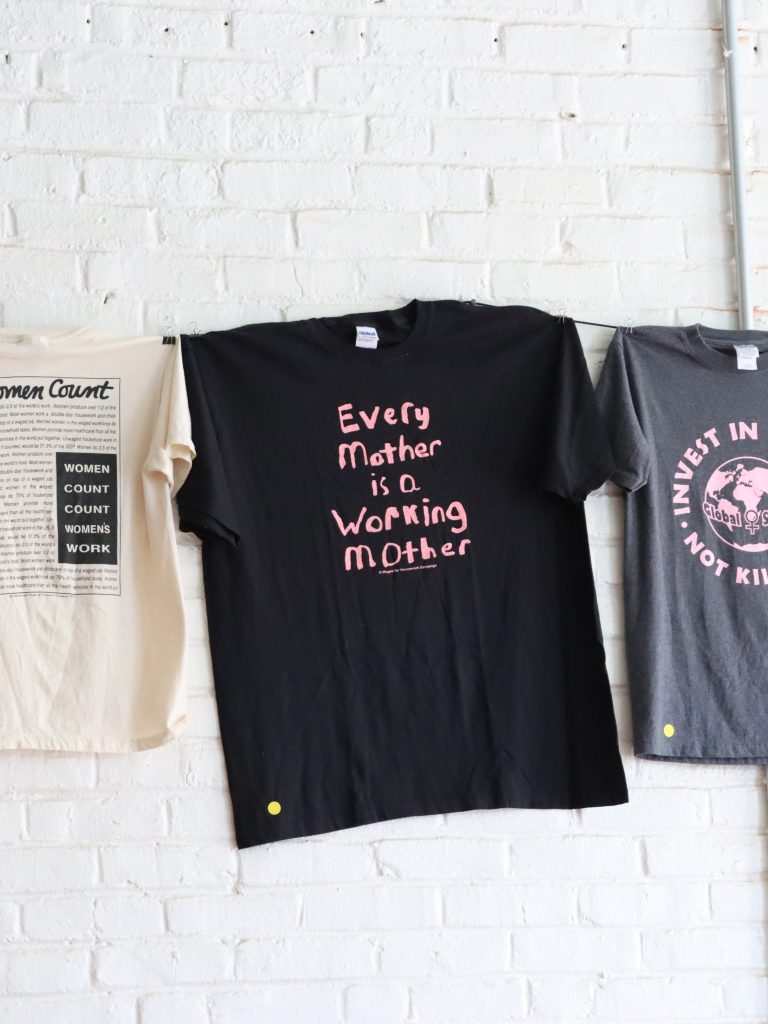 Shirts with messaging affirming wages for care work, which hang in the Crossroads Women’s Center on Wayne Avenue. (Photo: Rasheed Z. Ajamu)