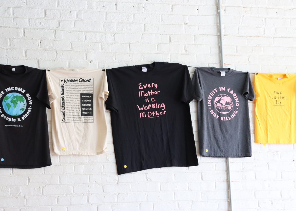 Shirts with messaging affirming wages for care work, which hang in the Crossroads Women’s Center on Wayne Avenue. (Photo: Rasheed Z. Ajamu)