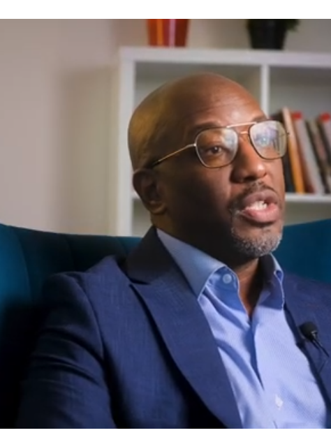 Sulaiman Rahman sits in a chair being interviewed for a video.