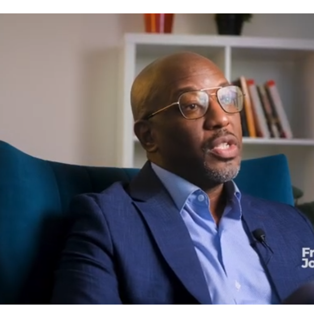 Sulaiman Rahman sits in a chair being interviewed for a video.