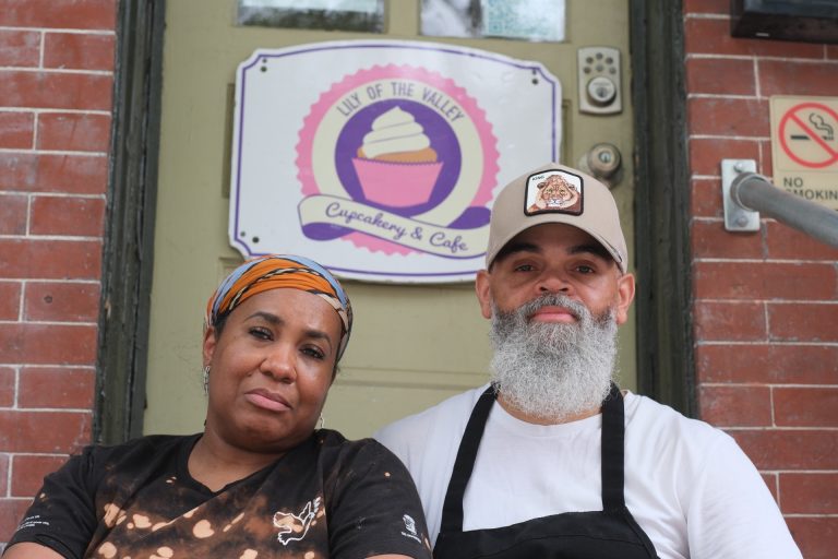 Photo of Terrance and Rashida Baldwin on the steps in front of Lily of the Valley bakery that they have run for 13 years.