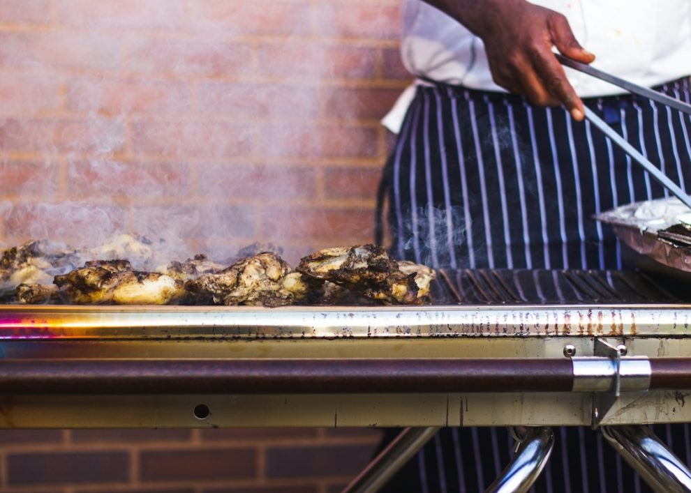 Stock image of a person grilling chicken.