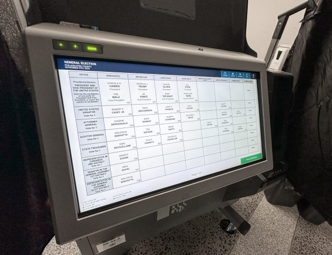 Electronic voting machine displaying a ballot screen with various candidate names and positions.