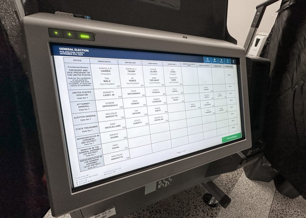 Electronic voting machine displaying a ballot screen with various candidate names and positions.