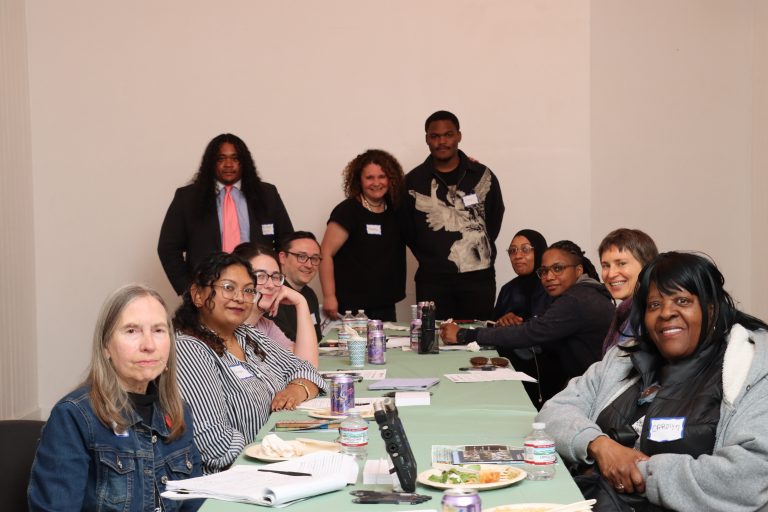 Germantown residents and staff of Germantown Info Hub gather around a table at an April discussion of the "benefits cliff" at the Our House Cultural Center.