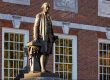 A statue of George Washington stands in front of Independence Hall as the sun rises over Philadelphia.
