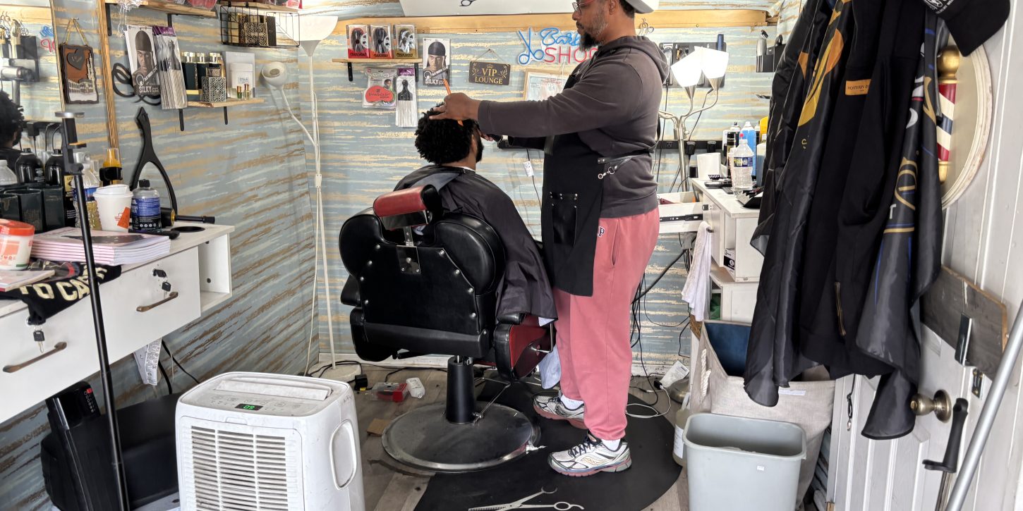 Siddiq, owner of Nicecutz Barber Truck cuts the hair of a customer.