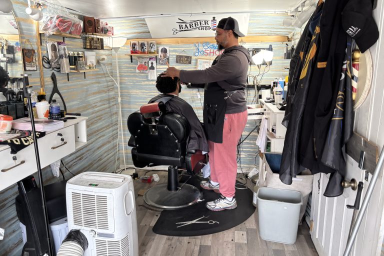 Siddiq, owner of Nicecutz Barber Truck cuts the hair of a customer.