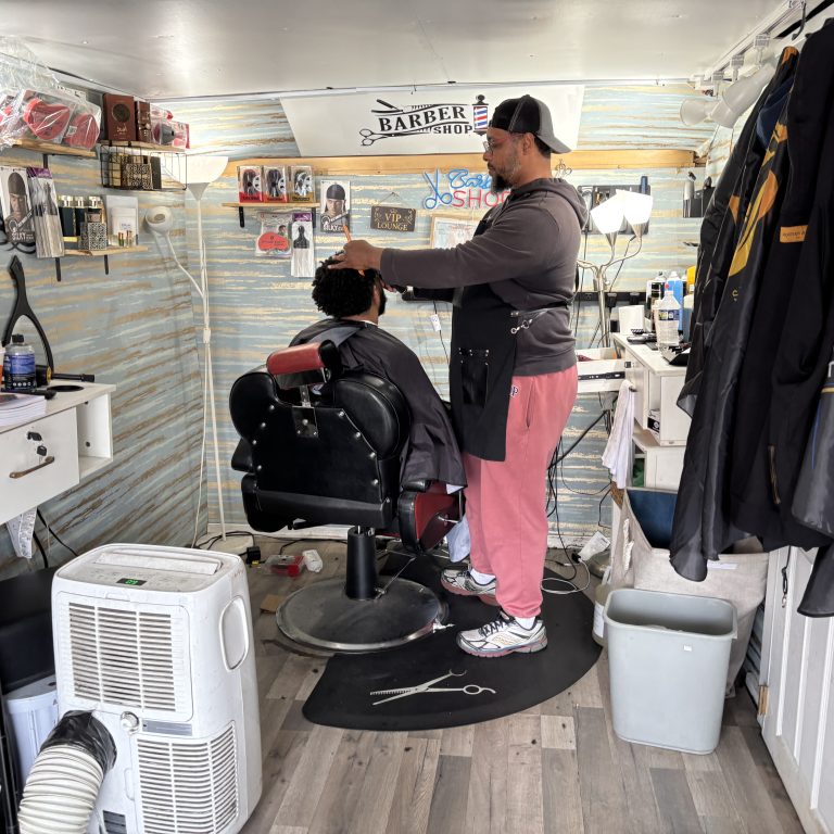 Siddiq, owner of Nicecutz Barber Truck cuts the hair of a customer.