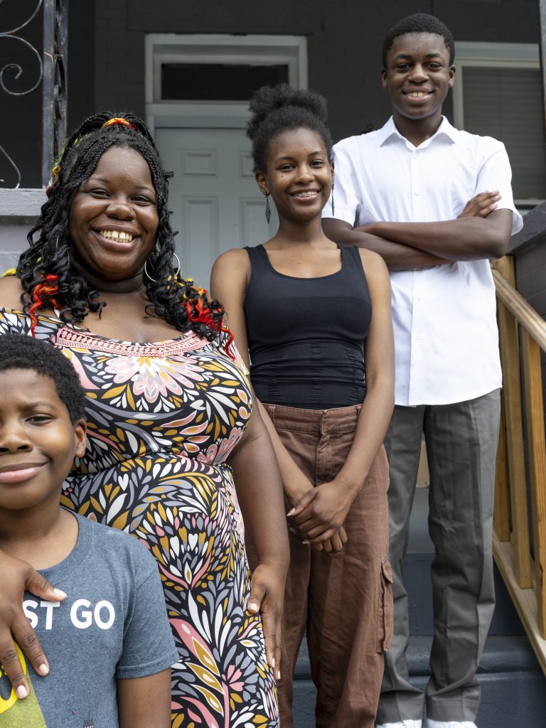 Michelle “MiMi” Gravley, 38, and her children — from left to right: Boots, 11, Buttons, 17, and Chippy, 14 — stand on the porch of their North Philadelphia home.