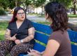Linda Hernandez sits on a bench in Jefferson Square Park, talking with reporter Valeria Uribe.