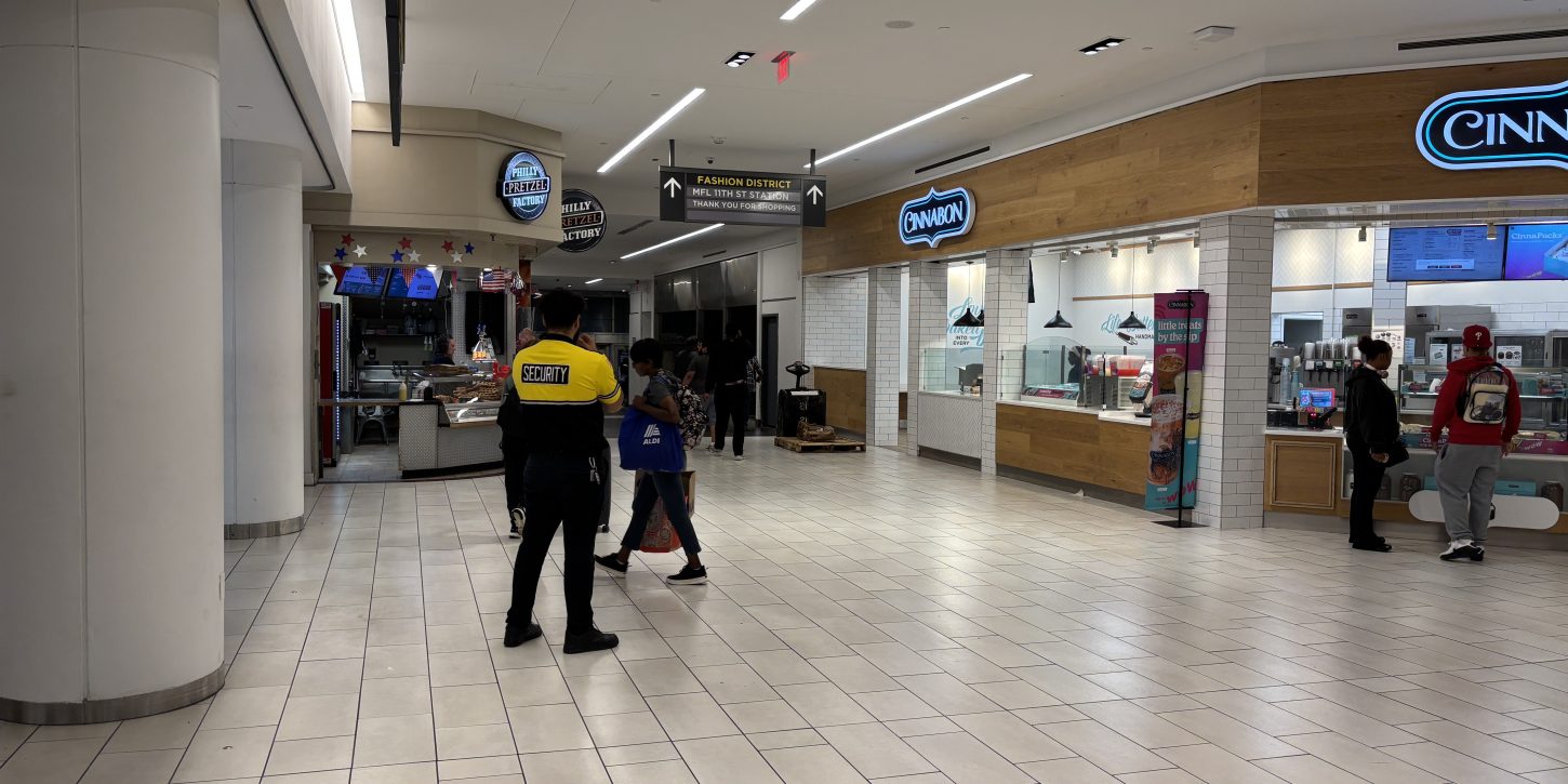 A security guard watches the entrance to Fashion District mall from the Market Frankfort Line.
