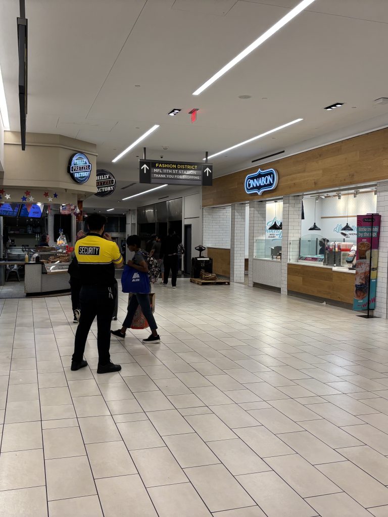A security guard watches the entrance to Fashion District mall from the Market Frankfort Line.